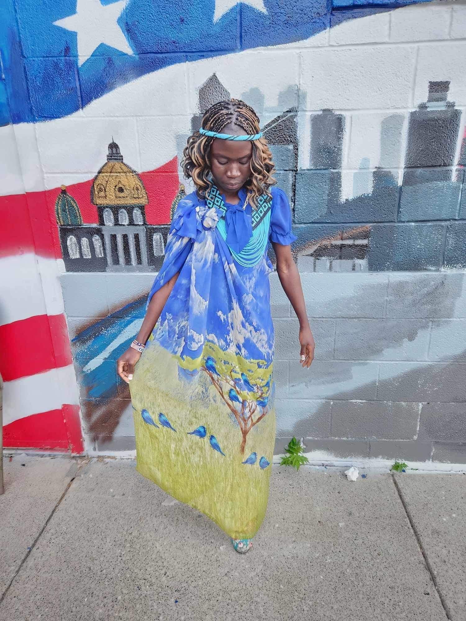 Woman by blue mural